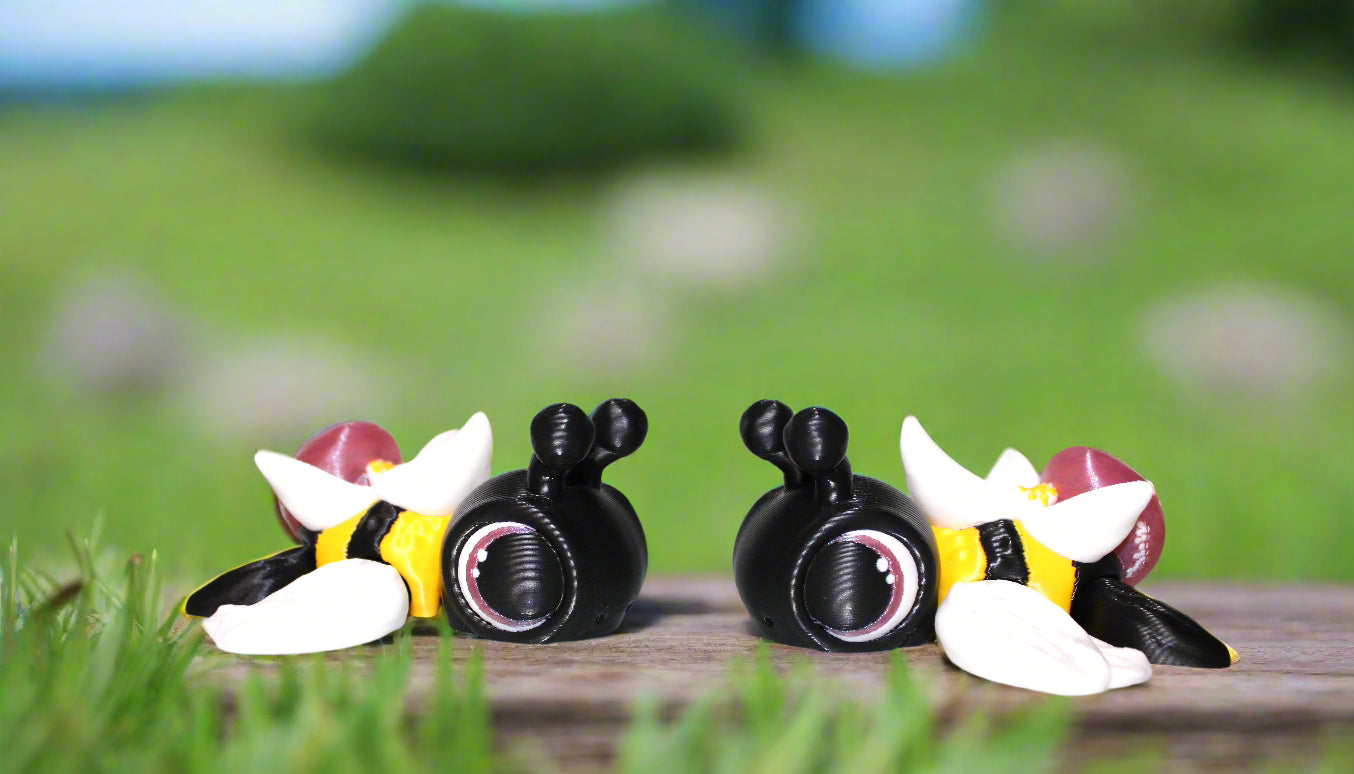 Three cartoon bee figurines on a white surface with a light background