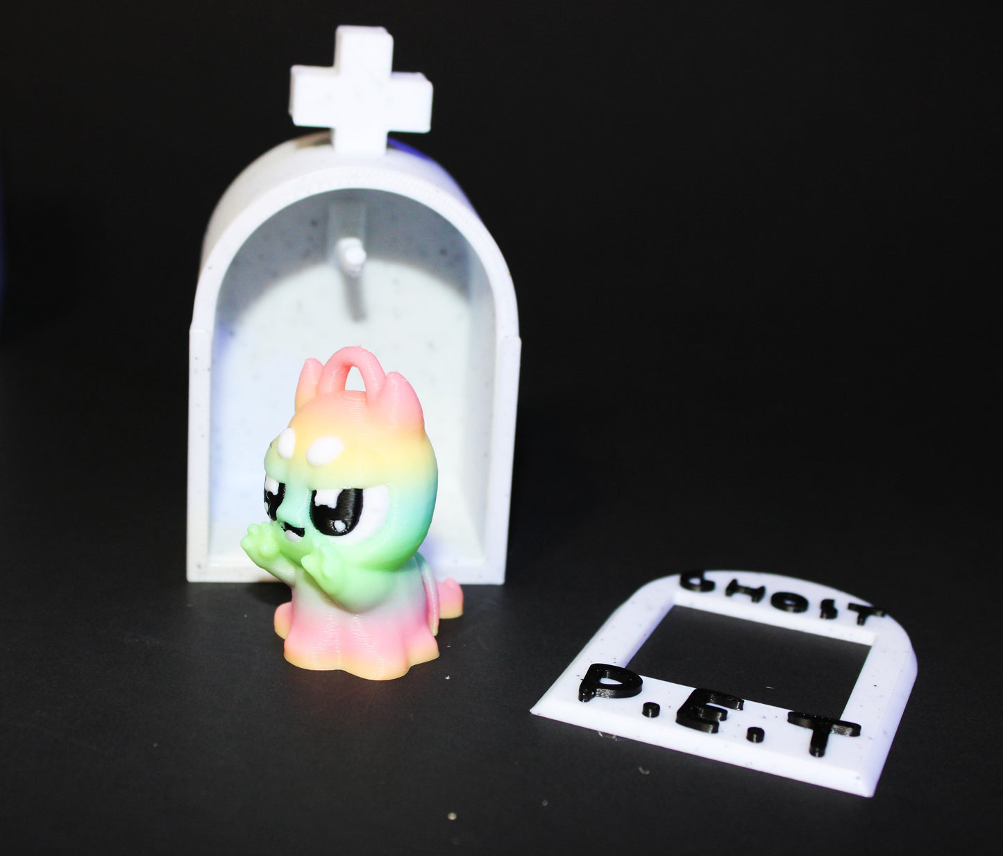 3D-printed glow-in-the-dark or blacklight ghost pets, complete with a tombstone accessory. - Wonderland 3D Printing