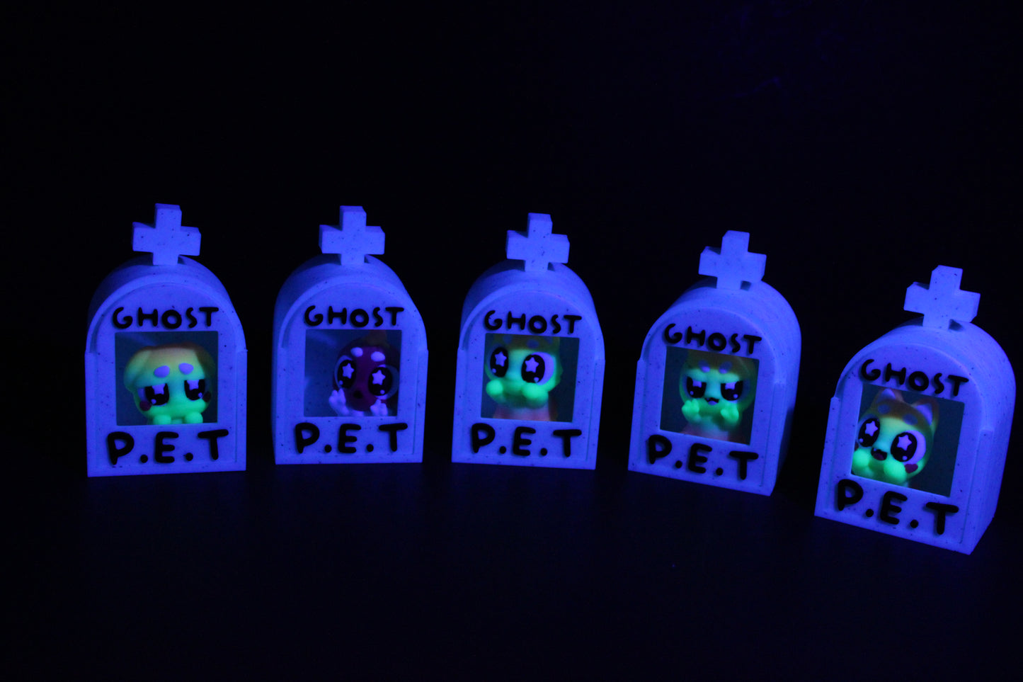 3D-printed glow-in-the-dark or blacklight ghost pets, complete with a tombstone accessory. - Wonderland 3D Printing
