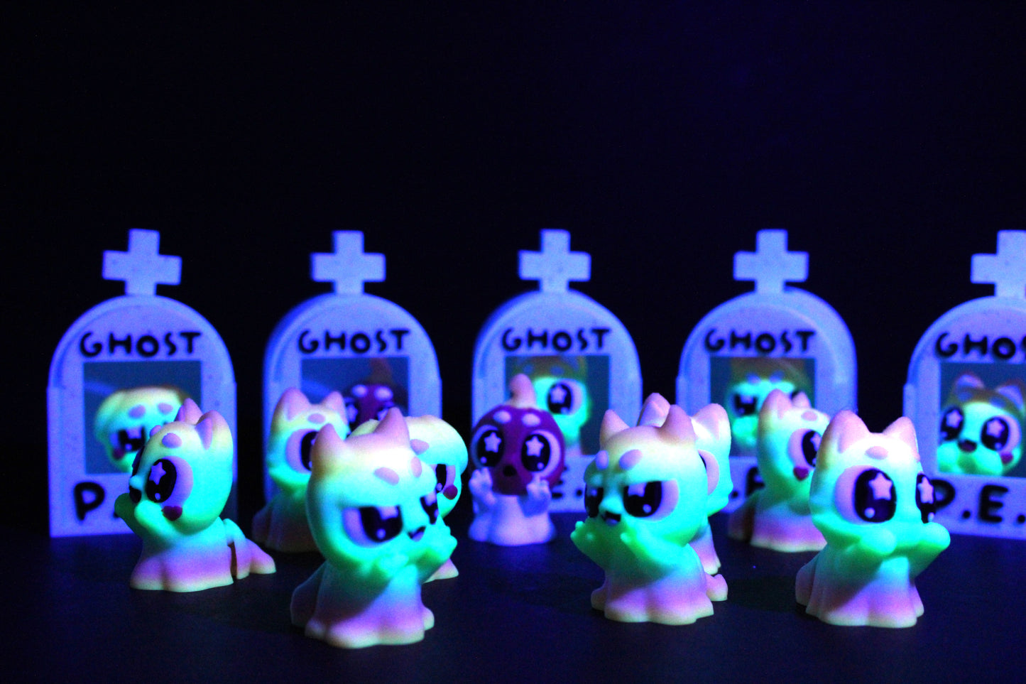 3D-printed glow-in-the-dark or blacklight ghost pets, complete with a tombstone accessory. - Wonderland 3D Printing
