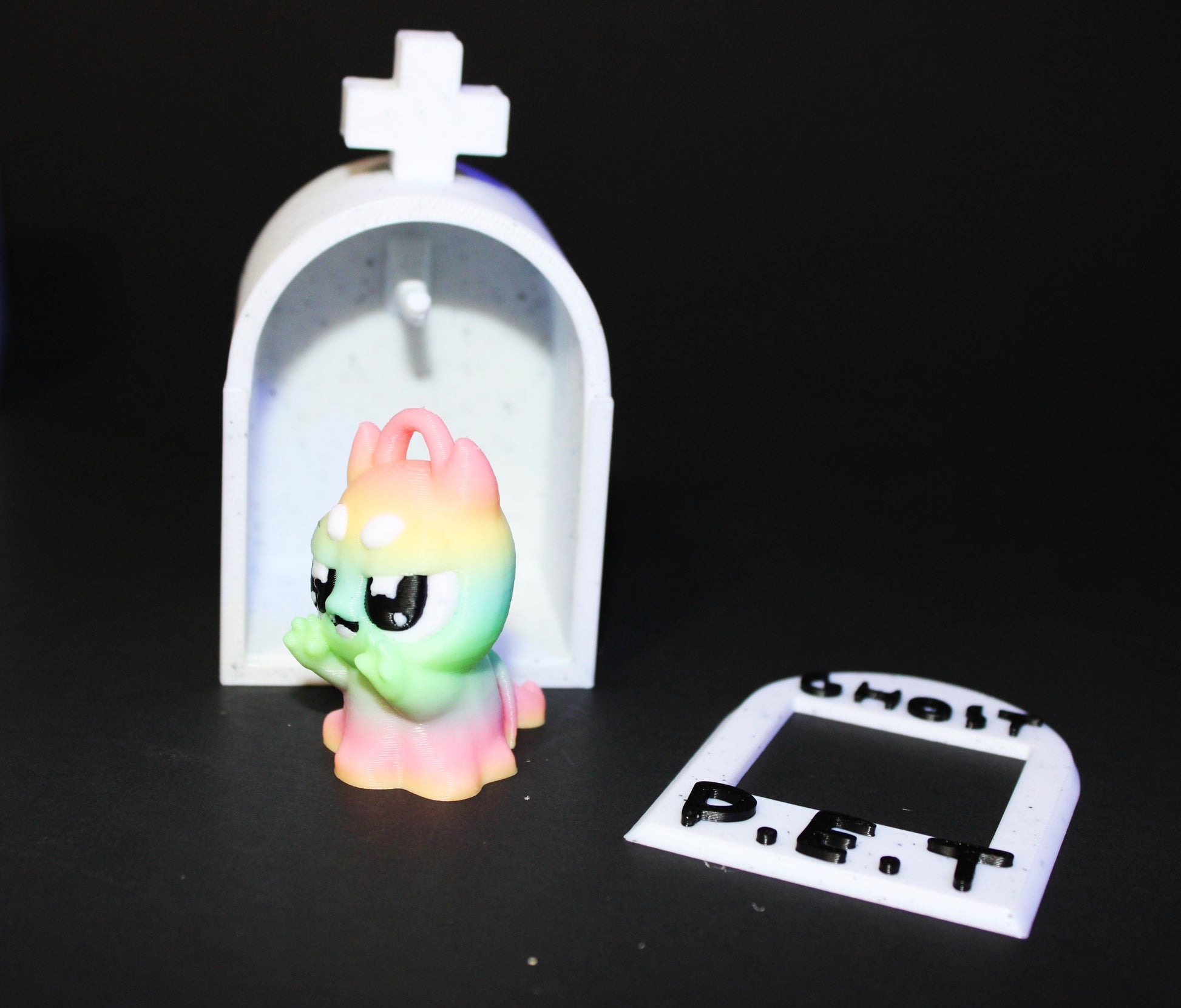 3D-printed glow-in-the-dark or blacklight ghost pets, complete with a tombstone accessory. - Wonderland 3D Printing 