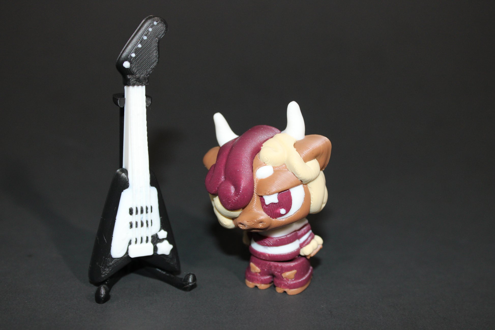 3D-printed Flexi Emo Cow with Guitar 2" Tall - Wonderland 3D Printing 